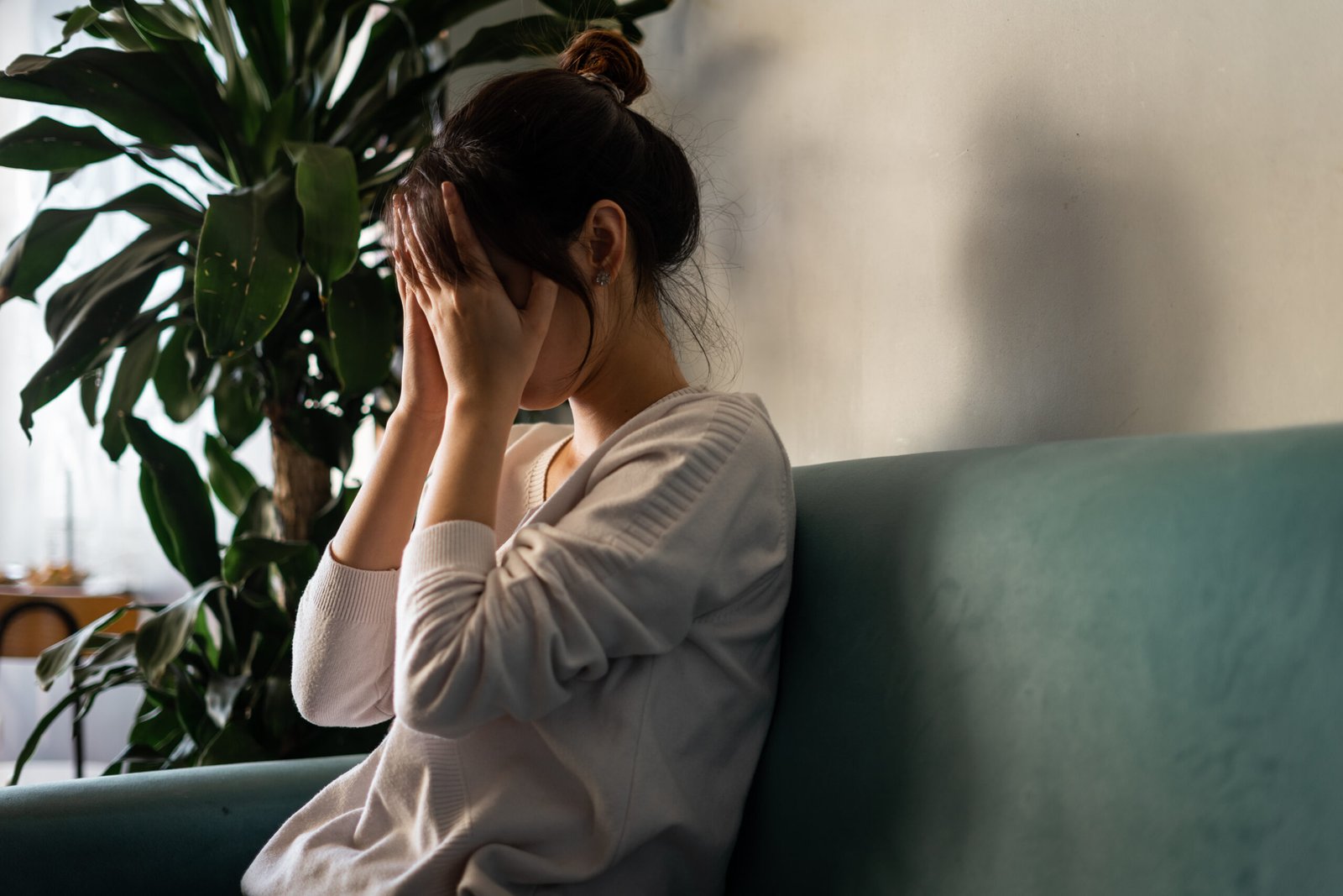 Stressed woman sitting on sofa at home